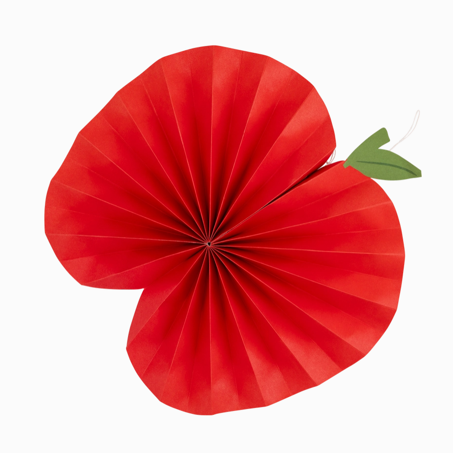 Red paper fan decoration with a green leaf on a white background