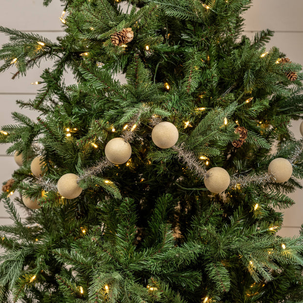 Decorated Christmas tree with lights and cream-colored ornaments