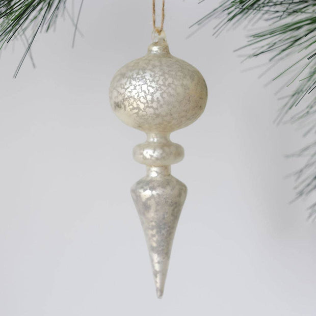 Decorative Christmas ornament hanging from a tree branch with a plain background