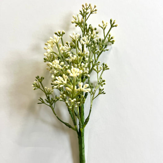 A single stem of artificial baby's breath with green leaves and white flowers.