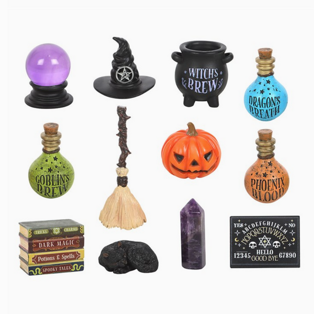 Collection of Halloween-themed decorative items including bottles, a broom, and a pumpkin on a white background.