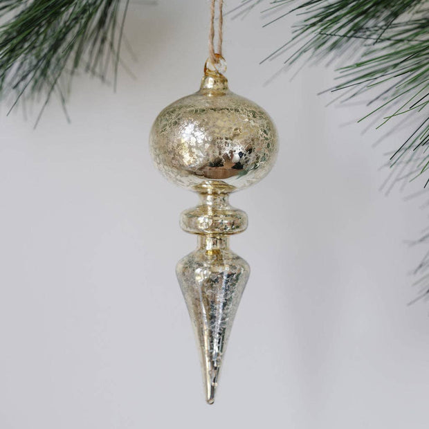 Decorative Christmas ornament hanging from a tree branch with a plain background