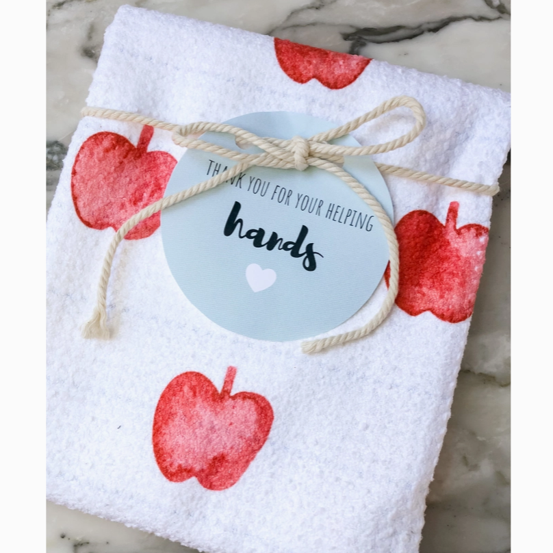 White towel with red apple designs and a 'thank you for your helping hands' tag.