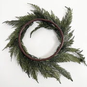 Green wreath with a brown wooden frame on a white background