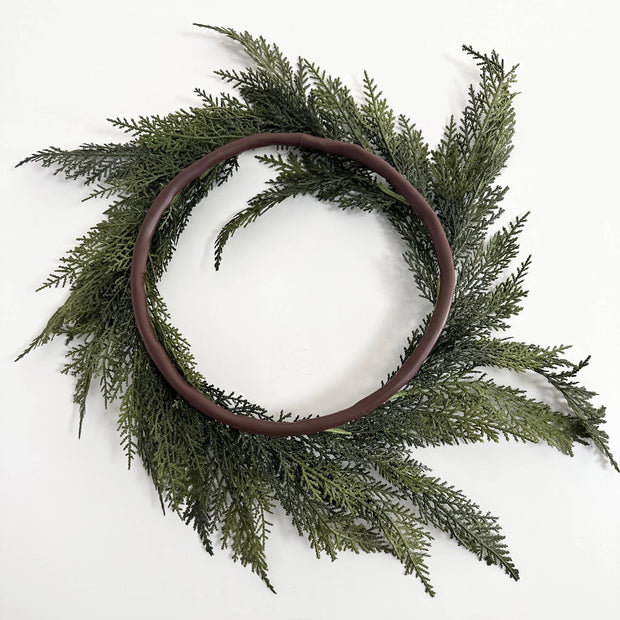 Green wreath with a brown wooden frame on a white background