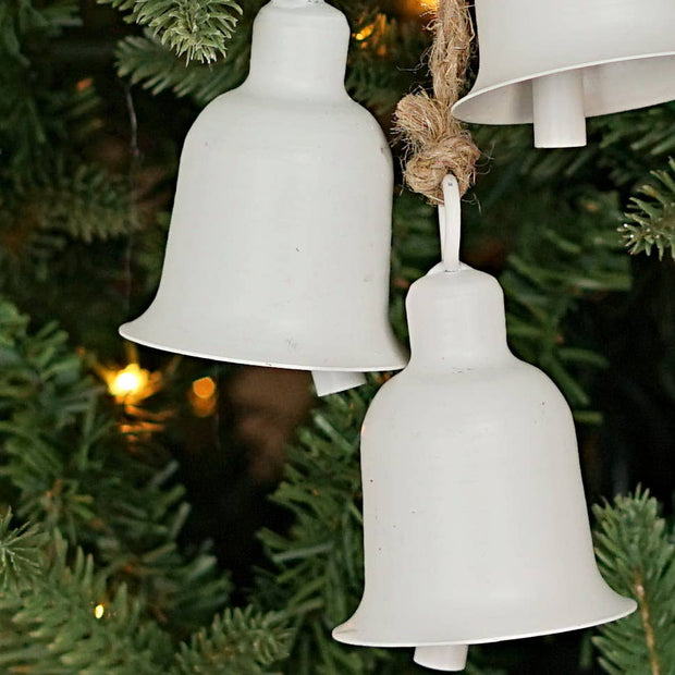White metal bells hanging on a Christmas tree