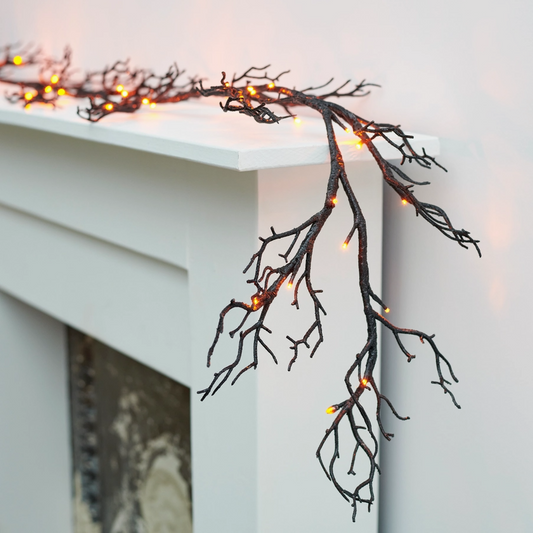 illuminated twig garland on fireplace mantle