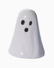 White ghost-shaped object with black dots on a white background