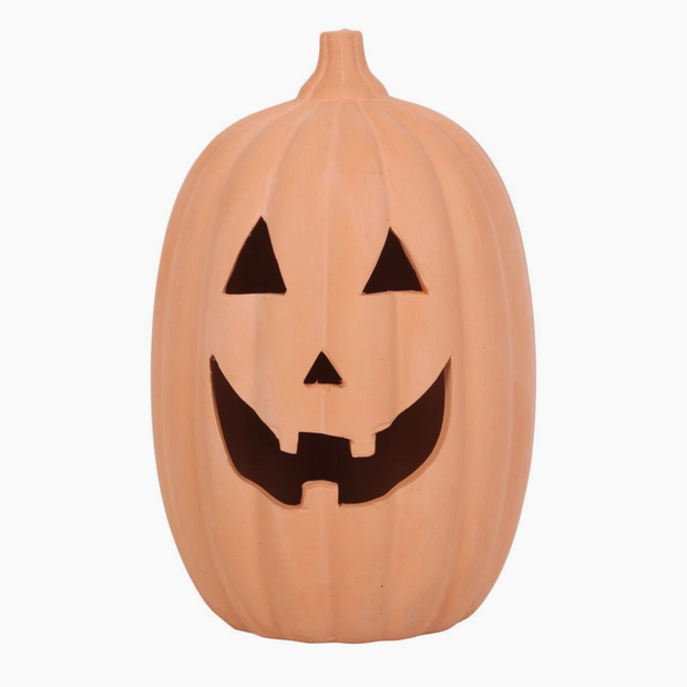 Pumpkin-shaped container with a carved face on a white background
