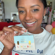 Person holding a product with 'Lunch Box Notes' text in a casual setting