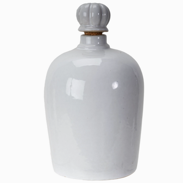 White ceramic jar with a decorative cap on a white background