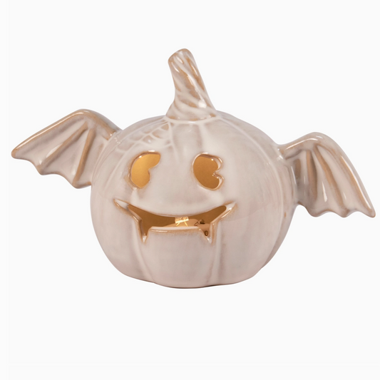 Illuminated jack-o'-lantern with bat wings on tabletop