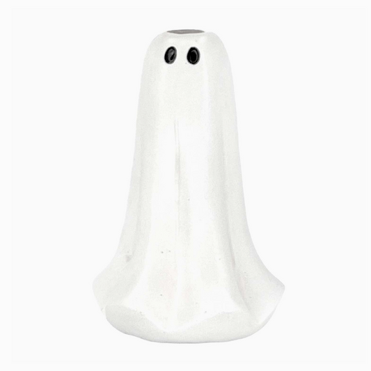 Ghost-shaped taper candle holder on a Halloween table