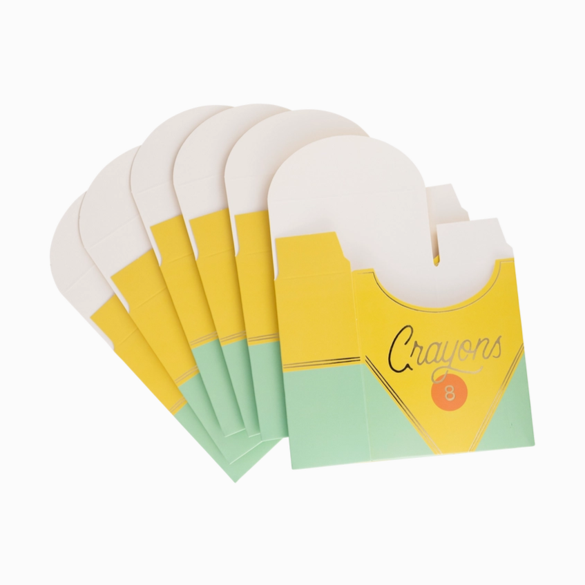 Set of six crayon packages with yellow and green design on a white background