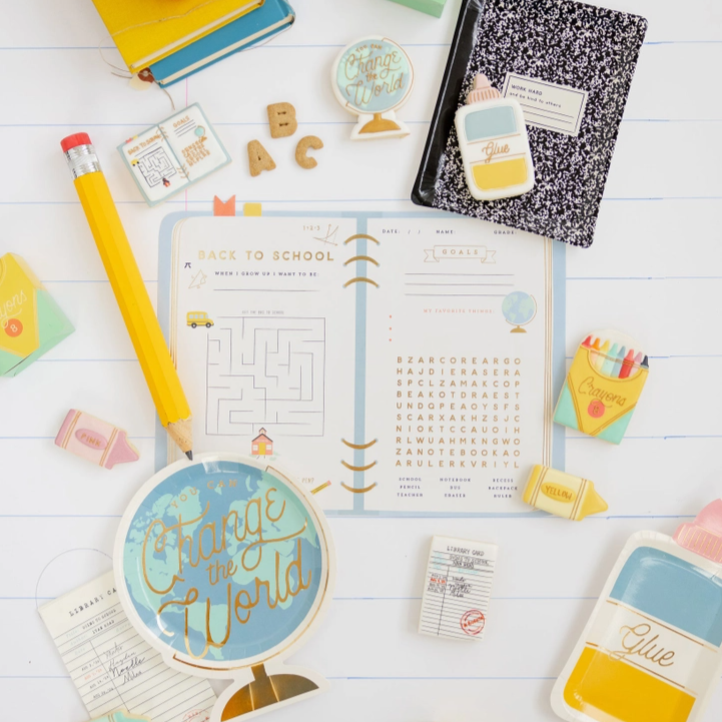 Back-to-school supplies including a planner, pencils, and stationery items on a white surface.