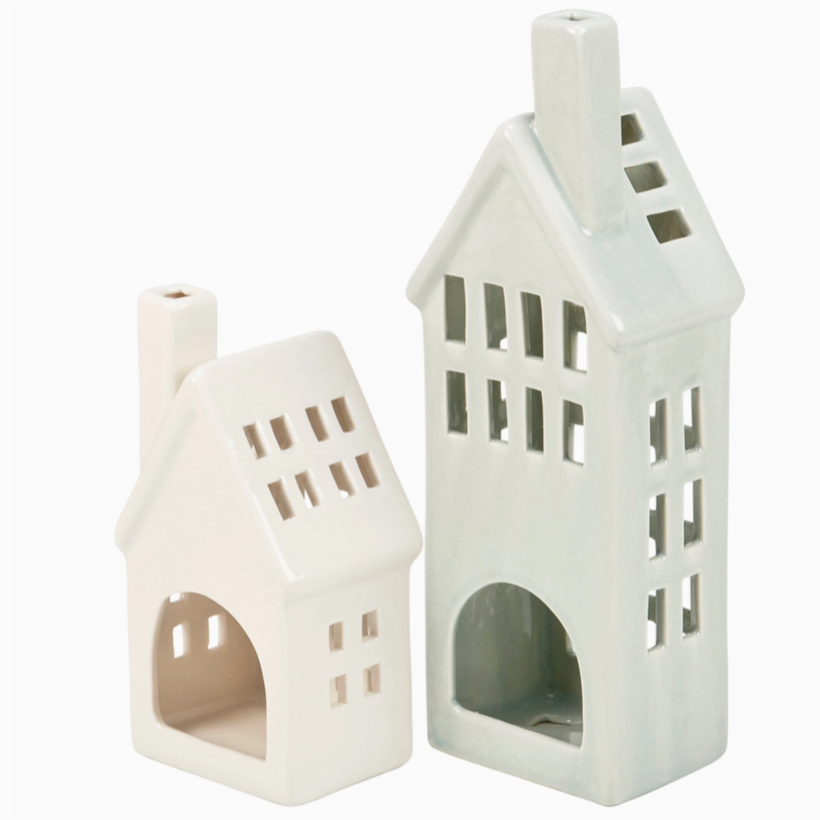 Two white ceramic house-shaped lanterns on a white background