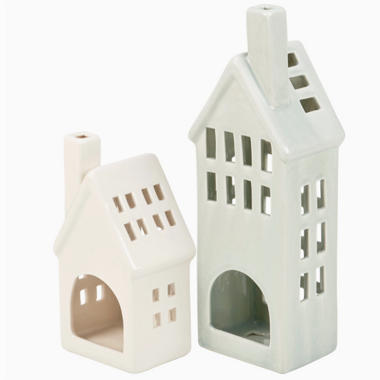 Two white ceramic house-shaped lanterns on a white background