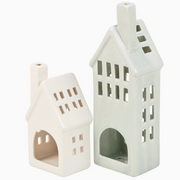 Two white ceramic house-shaped lanterns on a white background
