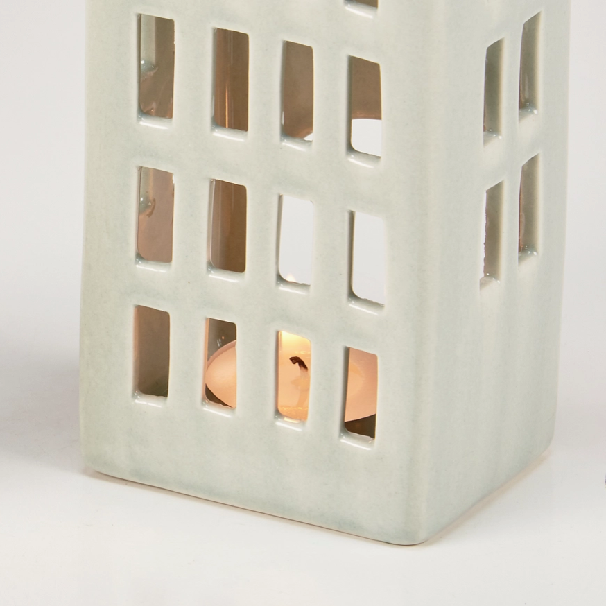 Decorative candle holder with cut-out patterns on a white background